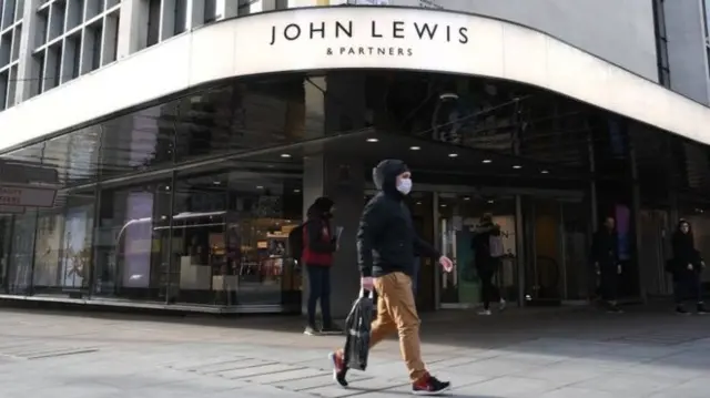 A shopper walks past John Lewis