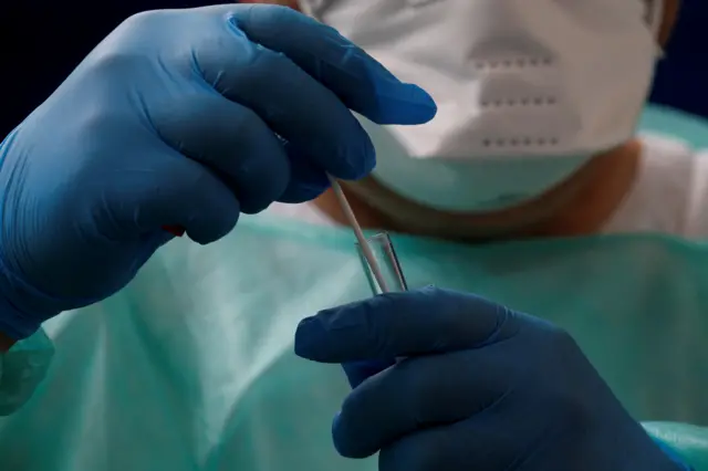 A French doctor holds a test tube after conducting a coronavirus test