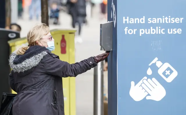 Woman using sanitiser in Leeds