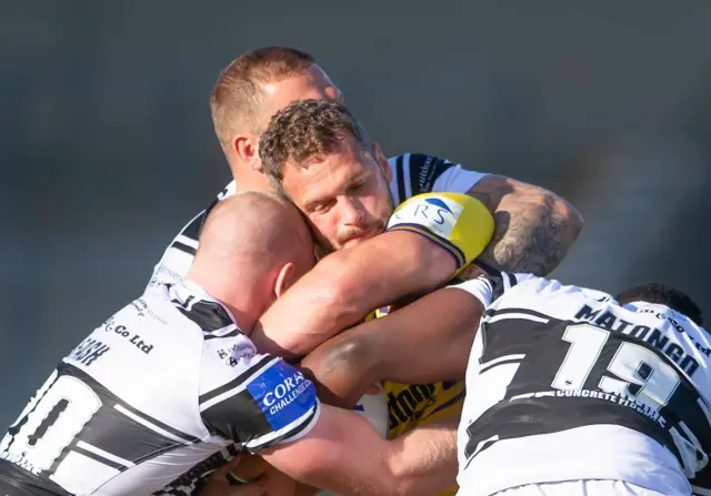 Wigan's Sean O'Loughlin is tackled by Hull FC's Danny Houghton & Masi Matongo.