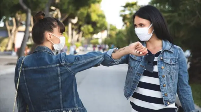 Two people elbow bumping