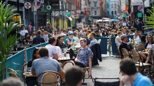 People sit at tables outside restaurants in Soho, amid the coronavirus disease (COVID-20) outbreak, in London, Britain, September 20, 2020.