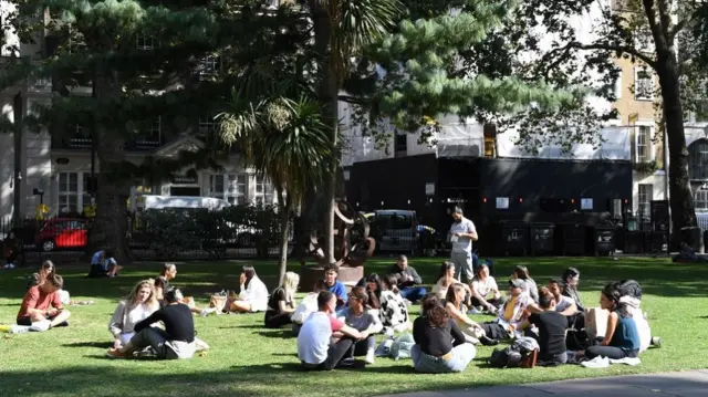 People sit in Soho square in London, Britain, 21 September 2020