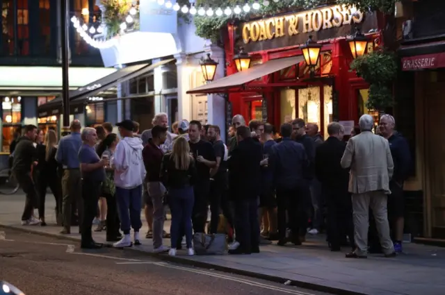 People outside the Coach and Horses pub in Wellington Street, London