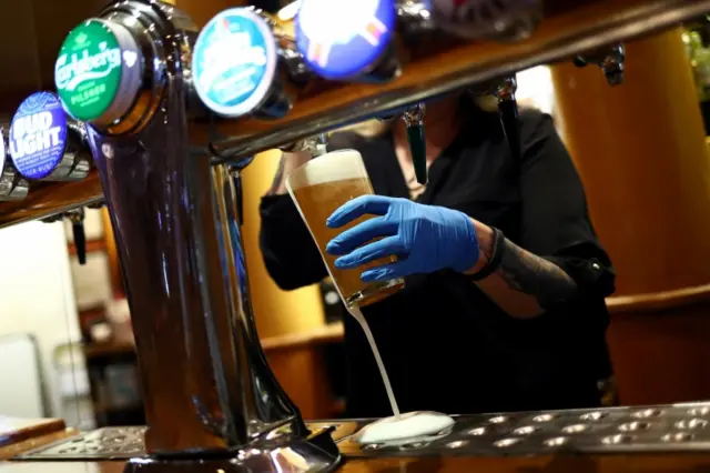 A worker pulling a pint at a Wetherspoons pub