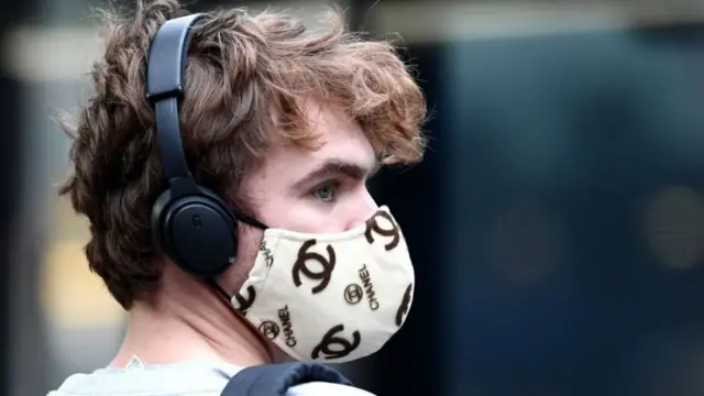 A man wears a Chanel-branded face mask