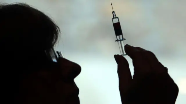 Stock photo of a nurse preparing to give a vaccine