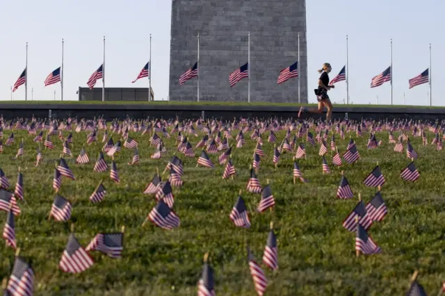 A jogger runs past thousands of US national flags