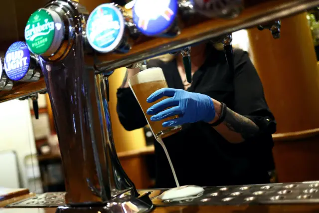 Bar staff serving a pint