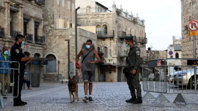 Israeli security personnel stand at a check point after Israel entered a second nationwide lockdown, 19 September