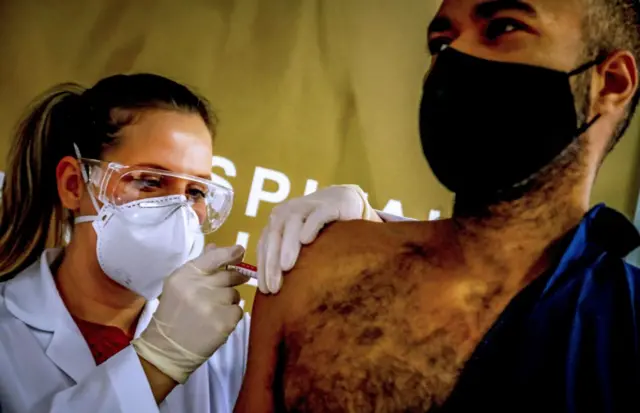 Health worker and volunteer Paulo Roberto Oliveira receives a COVID-19 vaccine produced by Chinese company Sinovac Biotech