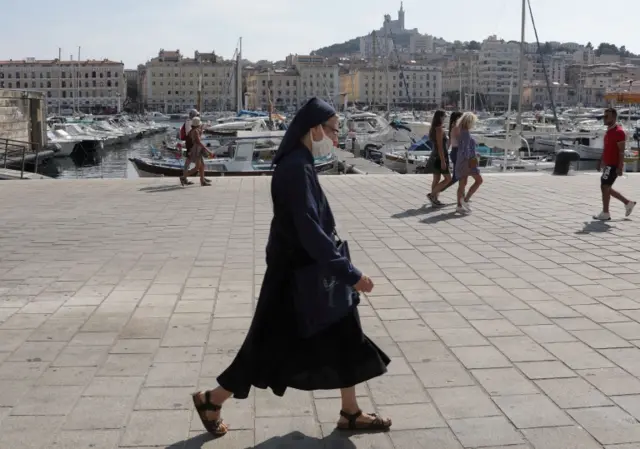 A nun wearing a face mask walks in Marseille