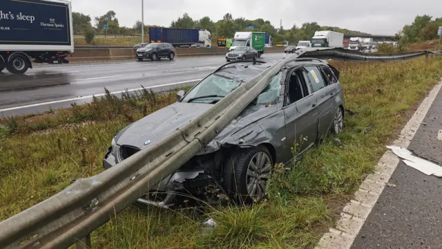 Car stuck under crash barrier