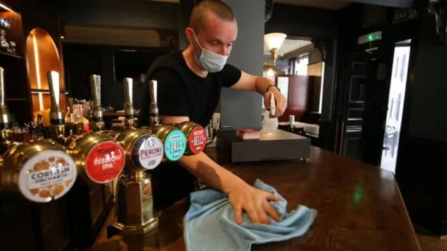 Pub worker cleaning a bar