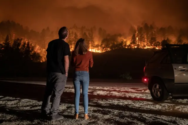 A man and a woman watch the Glass Fire burn in Calistoga, California