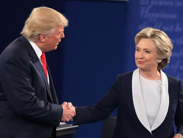 Donald Trump and Hillary Clinton shake hands at a debate in 2016