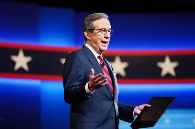 Fox News anchor and moderator Chris Wallace speaks to the debate audience