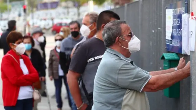 People wait in a queue outside a cultural centre before a coronavirus disease (COVID-19) antigen test in the working class neighbourhood of Vallecas, which has been under partial lockdown, in Madrid, Spain,