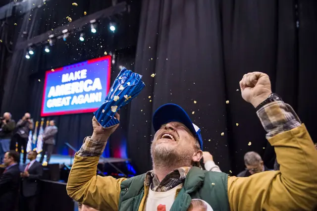 A Trump supporter throws popcorn ecstatically