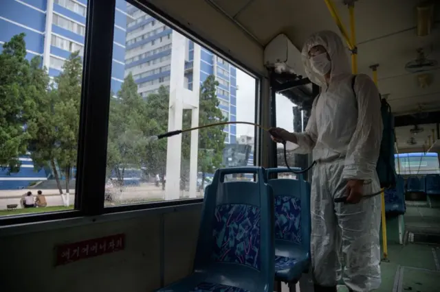 Staff member of the Ryonmot Trolley Bus Office disinfects a trolley bus as a protective measure against the coronavirus, before service in Pyongyang on 13 August 2020