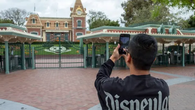 Disney fan taking pictures outside closed Disneyland gate