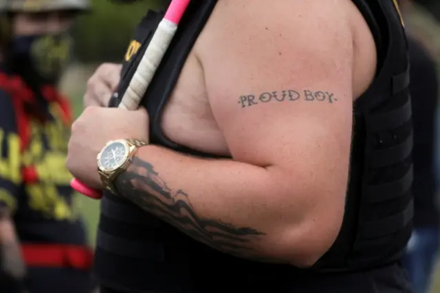 A tattoo is seen on a person's arm as people gather for a rally of the far-right group Proud Boys, in Portland, Oregon, on September 26, 2020.