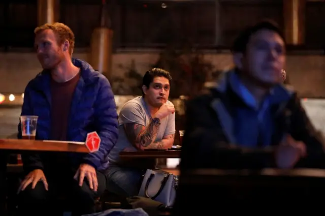 Americans living in Mexico react as they watch the first 2020 presidential campaign debate between U.S. President Donald Trump and Democratic presidential nominee Joe Biden at the Pinche Gringo restaurant in Mexico City