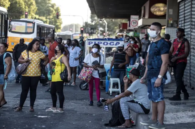 People wearing face masks to avoid the spread of coronavirus wait for a bus in Rio de Janeiro, Brazil, 3 September 2020