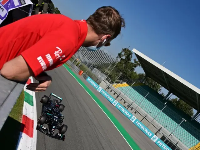 Sebastian Vettel watches Hamilton cross the line