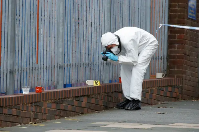 A forensic officer takes photos of a crime scene