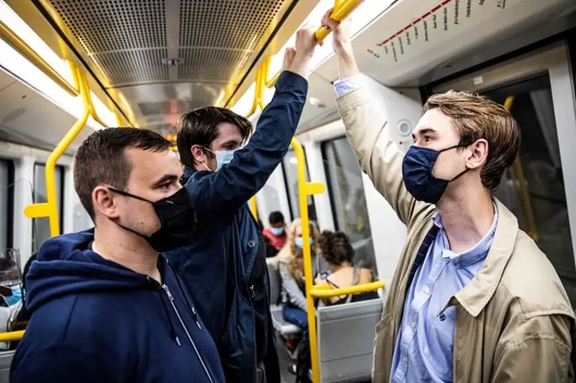 People wear mask on a metro train in Copenhagen shortly after midnight, on August 22, 2020