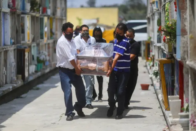 Relatives carry the coffin of Maria Eugenia, 71, who died from the coronavirus disease (COVID-19), during her funeral at the Municipal cemetery in Nezahualcoyotl, State of Mexico, Mexico, August 21, 2020.