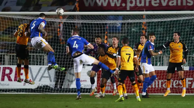 Lewis Dunk of Brighton wins a header against Newport