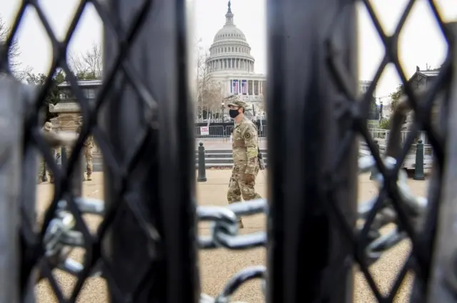 Soldiers seen through a fence