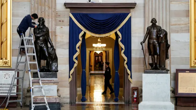 Gompo Yarmolinsky with the Architect of the Capitol cleans dust from the statue of Thomas Jefferson in the Capitol Rotunda after supporters of U.S. President Donald Trump stormed the U.S. Capitol in Washington, U.S., January 12, 2021