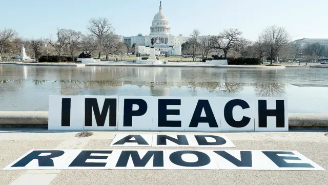 People gather at the base of the U.S. Capitol with large IMPEACH and REMOVE letters on January 12, 2021 in Washington, DC.