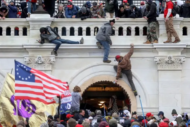 A mob of supporters of President Trump fight with members of law enforcement at a door they broke open as they storm the Capitol Building in Washington