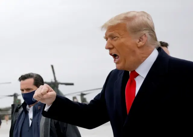 Trump shouts to supporters at the airport in Texas