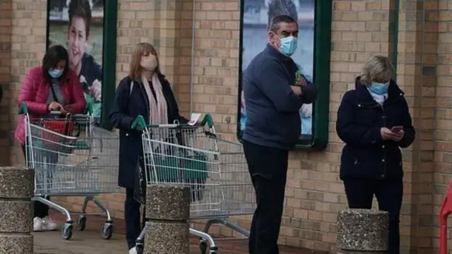 Shoppers in masks queuing