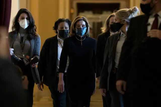 Speaker Nancy Pelosi and staff walk through the Capitol