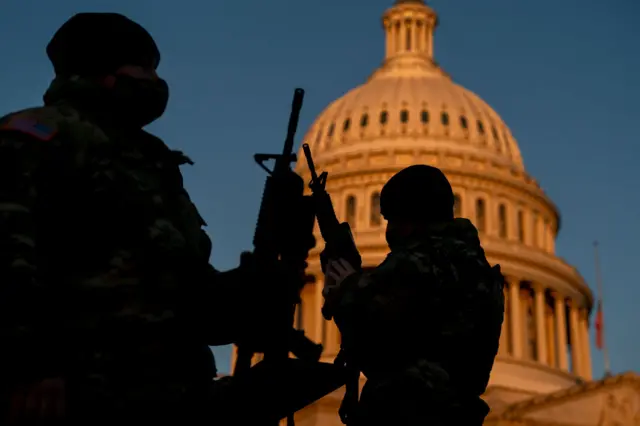 Soldiers inspect their guns on Wednesday outside the Capitol