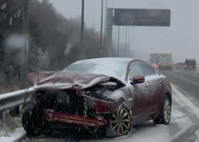 Crashed car at side of road in snow