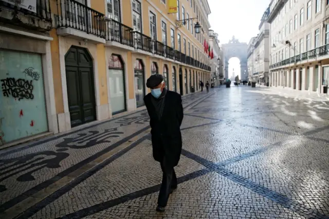 A man wearing a face mask walks in central Lisbon