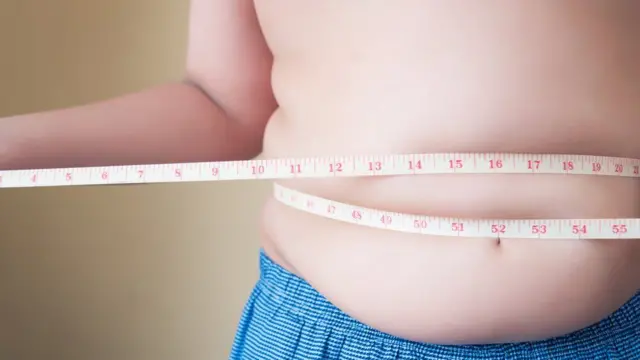 A child with a tape measure around their waist