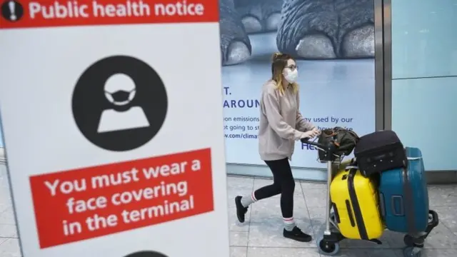 A traveller wearing a face mask at Heathrow airport