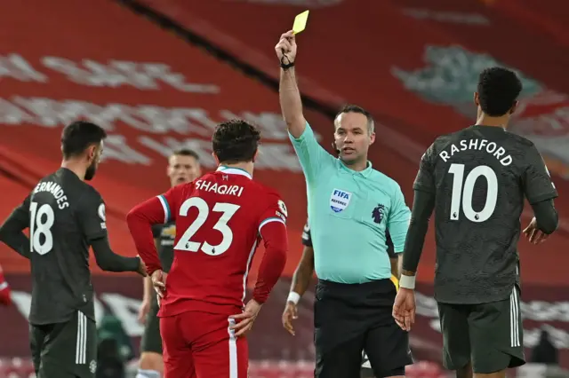 Xherdan Shaqiri is shown a yellow card