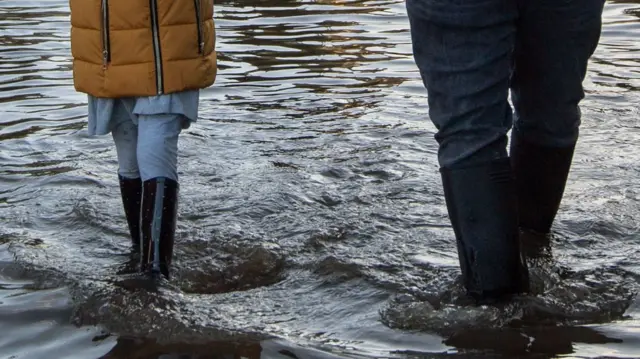 People walking through water