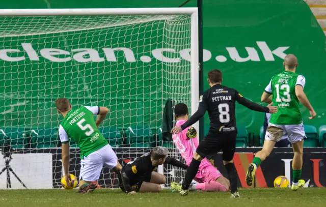 Scott Robinson (grounded) rolls in the third goal at Easter Road