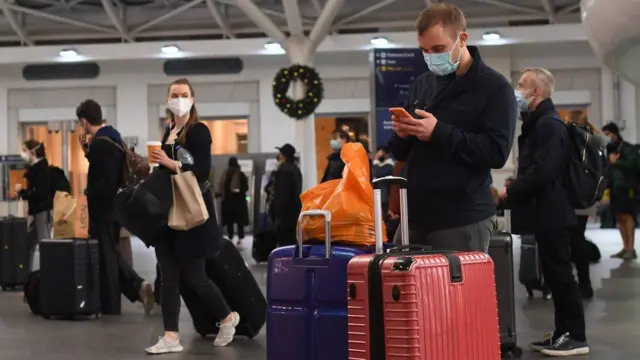 Travellers wearing masks at a train station