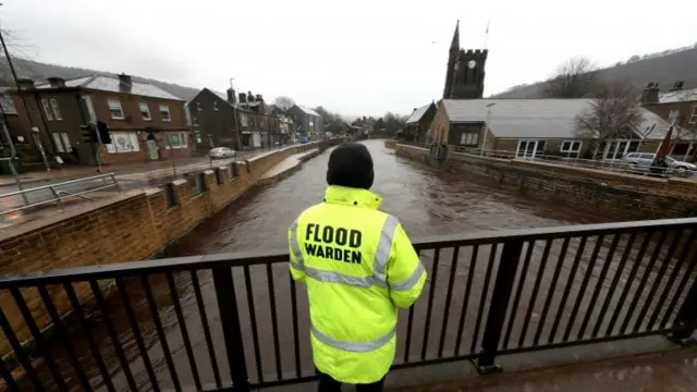 Flood warden looks at river in Mytholmroyd